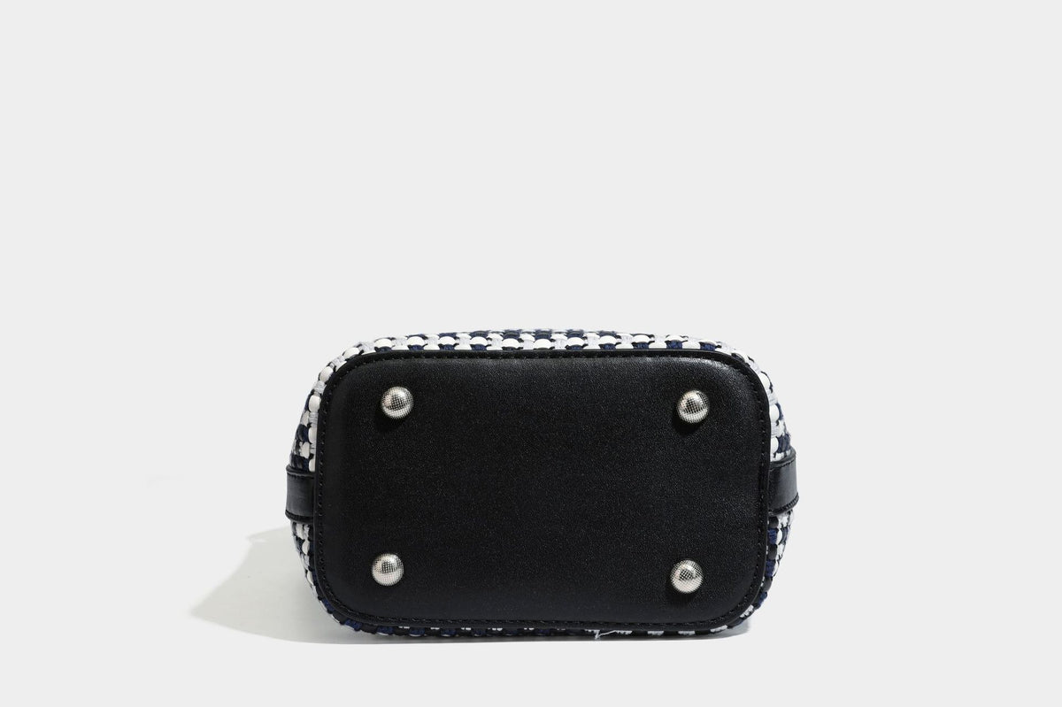 Small structured woven checker bucket bag with braided top handle, drawstring closure, and silver-tone hardware in black