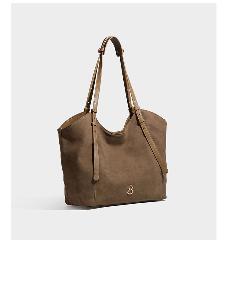 Oversized suede-finish tote shoulder bag in caramel brown with slim leather-look straps and gold-tone logo hardware, detail