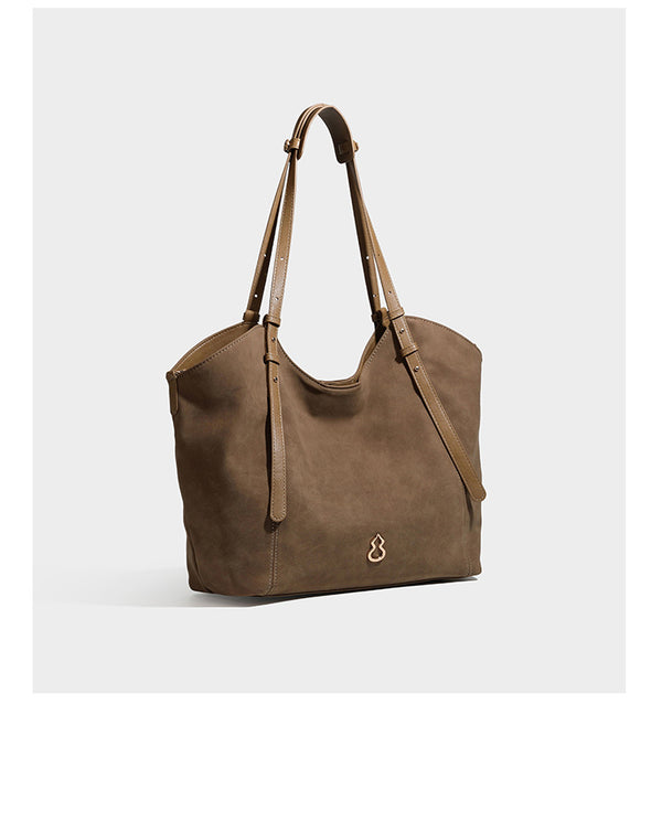 Oversized suede-finish tote shoulder bag in caramel brown with slim leather-look straps and gold-tone logo hardware, detail