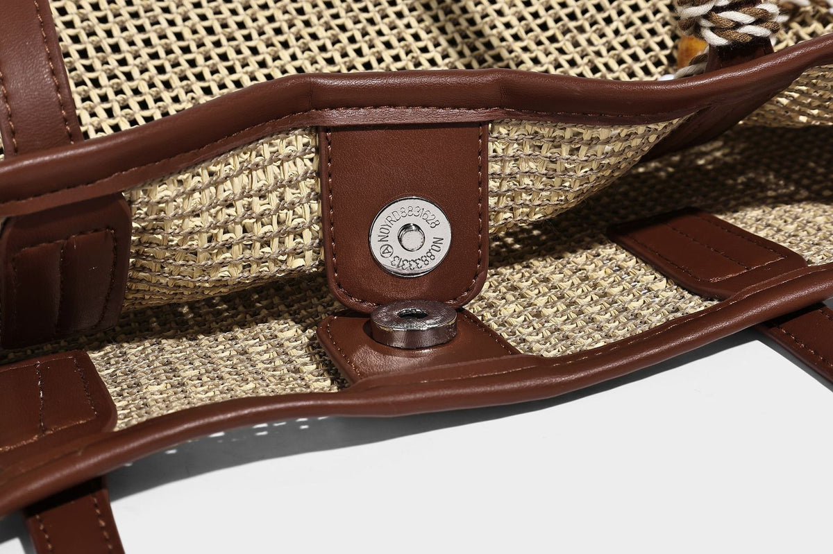 Große Tote-Bag aus grob geflochtenem Stroh in Beige und Creme mit dunkelbraunen Details in Lederoptik, langen Schulterriemen und einem mit Perlen verzierten