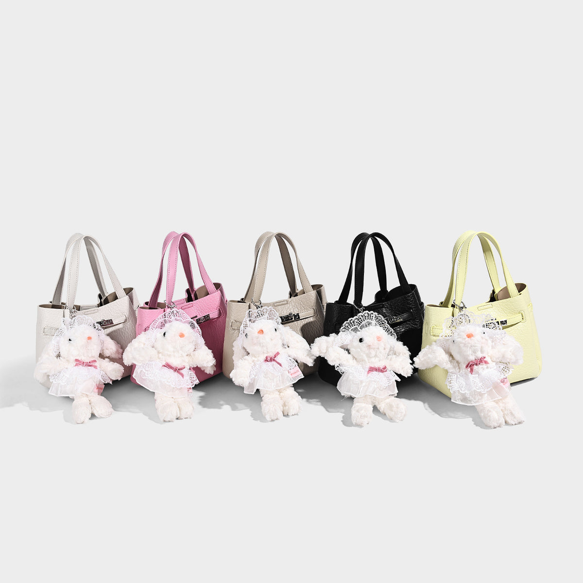 Small structured pebbled bucket tote with double top handles, silver turn-lock hardware, and detachable shoulder strap