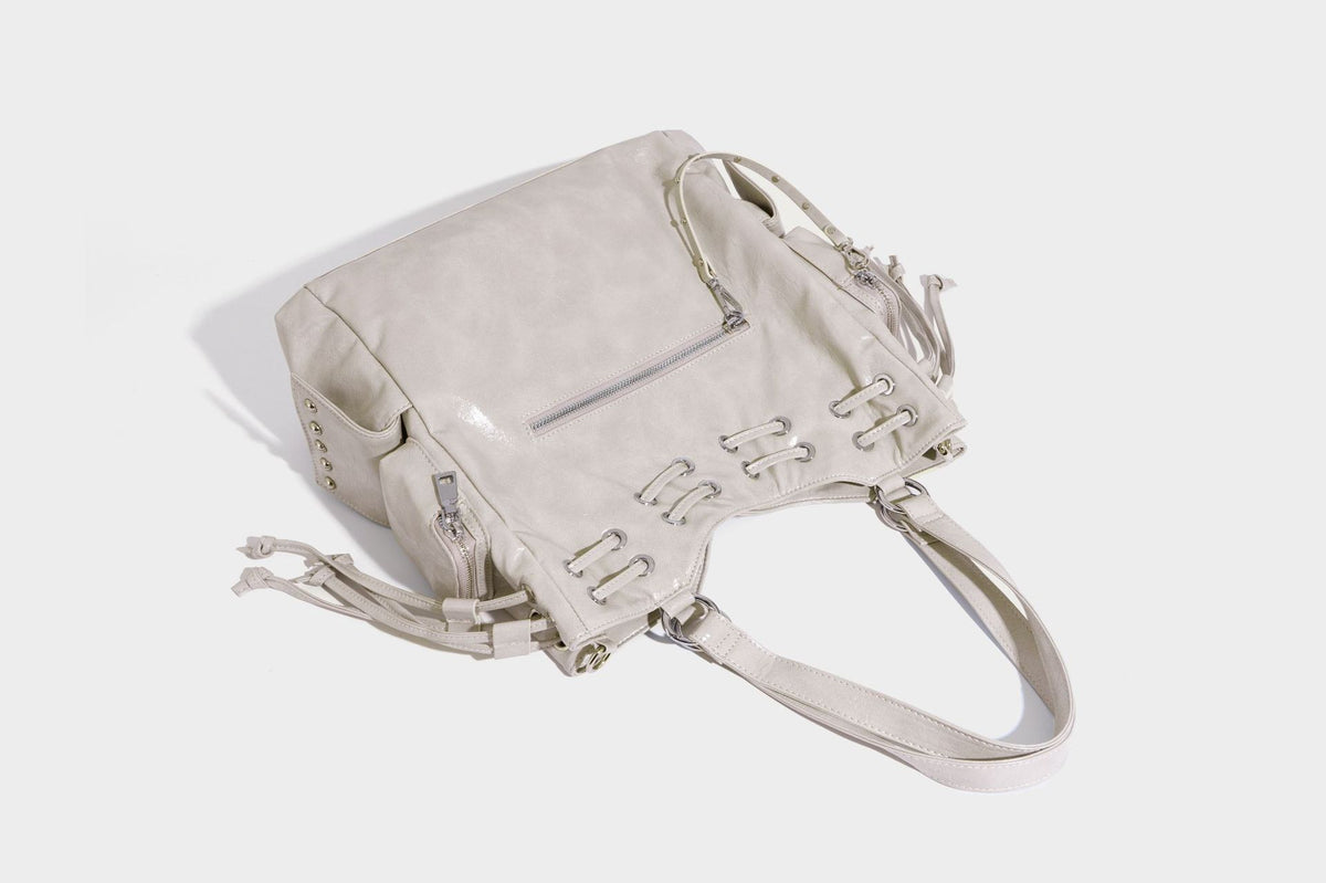 Glossy crinkled leather-look tote bag with silver grommet lace-up front detail, dual top handles, and detachable shoulder