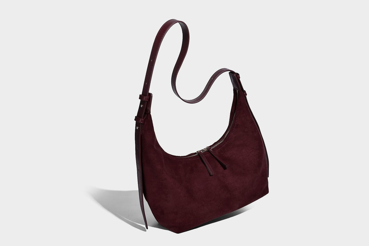Slouchy crescent hobo shoulder bag in dark chocolate matte suede-look finish with adjustable strap and twin-pull top zip