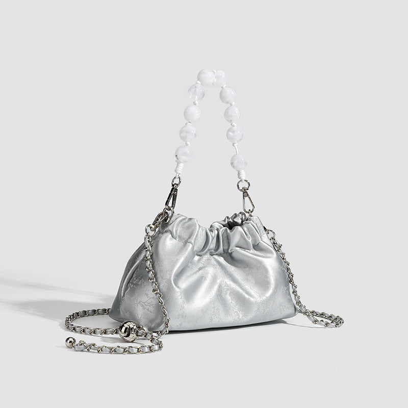 Small ruched drawstring pouch bag with pearl-bead handle and silver-tone chain strap, detail view 3