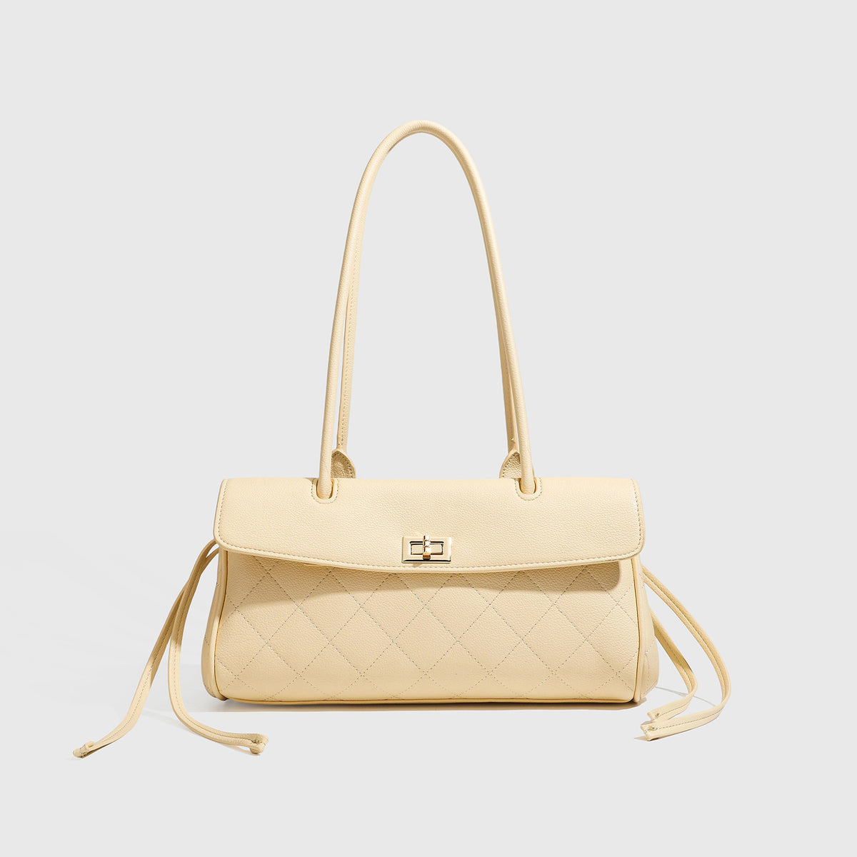 Structured black diamond-quilted shoulder bag with gold-tone turn-lock flap closure and dual round shoulder straps, detail