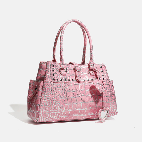 Blush pink glossy crocodile-embossed structured tote bag with studded trim, silver-tone hardware, double top handles, and