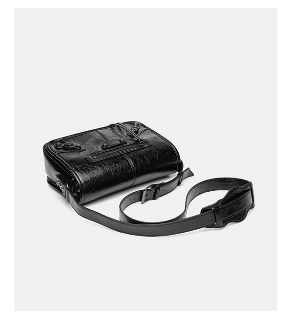 Small structured rectangular crossbody bag with crinkle leather-look finish, front zip pocket, gunmetal stud hardware, and