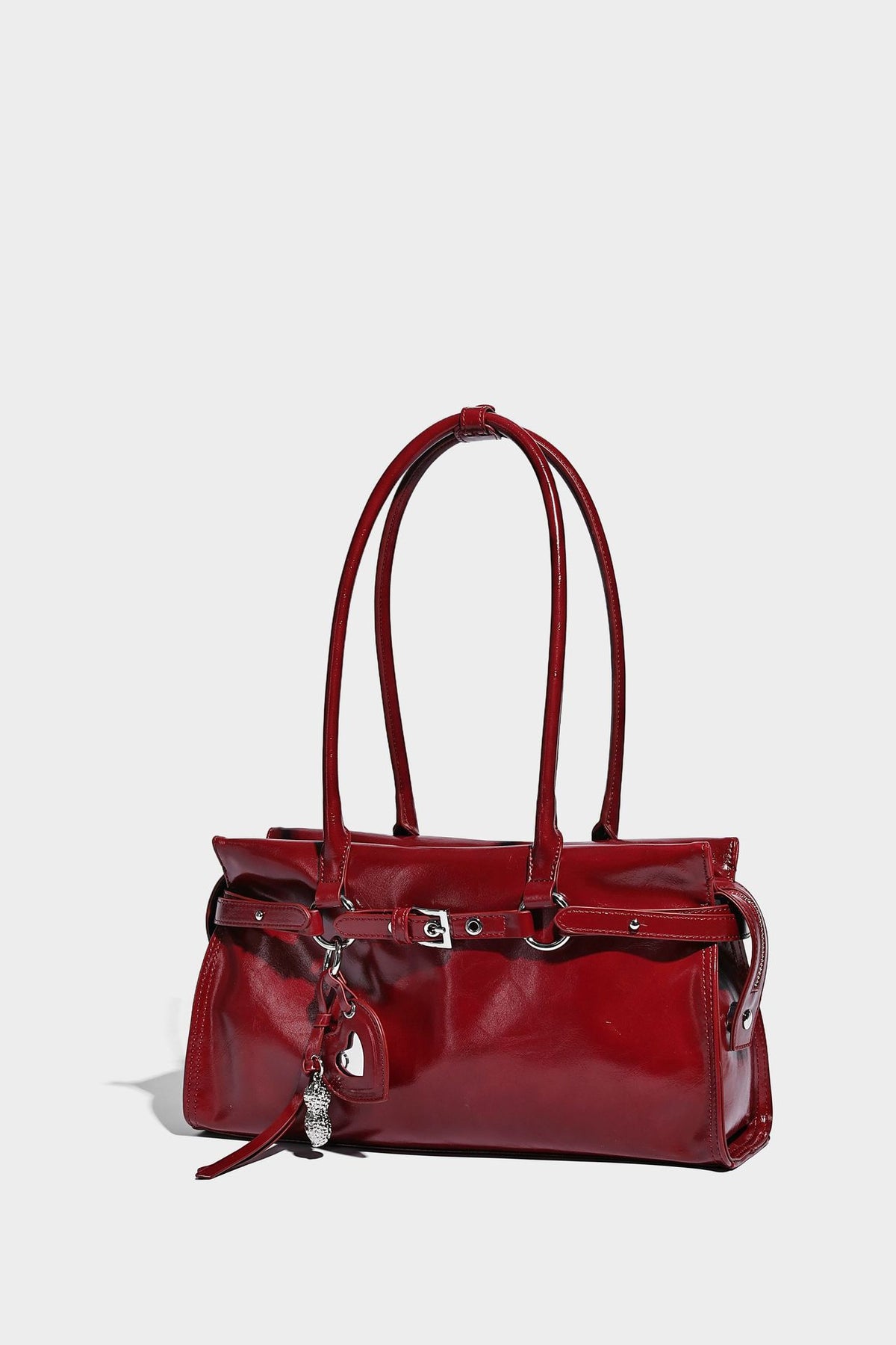 Structured rectangular glossy tote shoulder bag with belt buckle front strap and dangling charm hardware, detail view 17