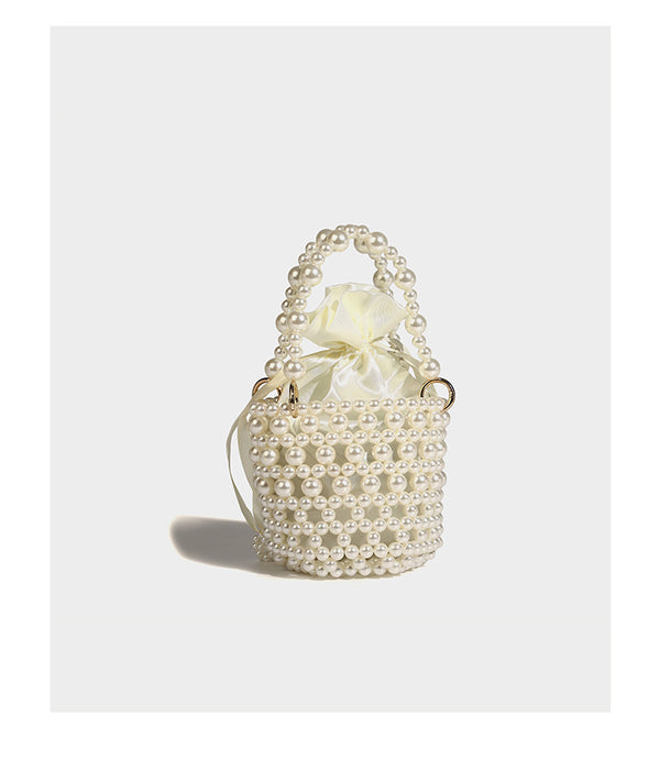Elfenbeinfarbene Mini-Bucket-Bag aus Kunstperlen mit Satin-Innenbereich und Zugband, goldfarbenen Ringbeschlägen und gewölbtem Perlenhenkel an der Oberseite