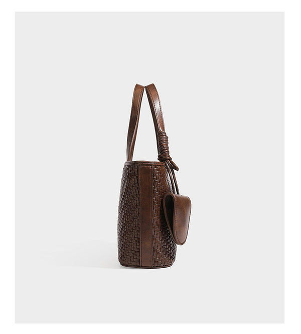 Strukturierte Tote Bag mit gewebter Oberfläche in Braun, goldfarbenen Metalldetails, seilumwickelten Tragegriffen, einer kleinen Fronttasche und weiteren Details