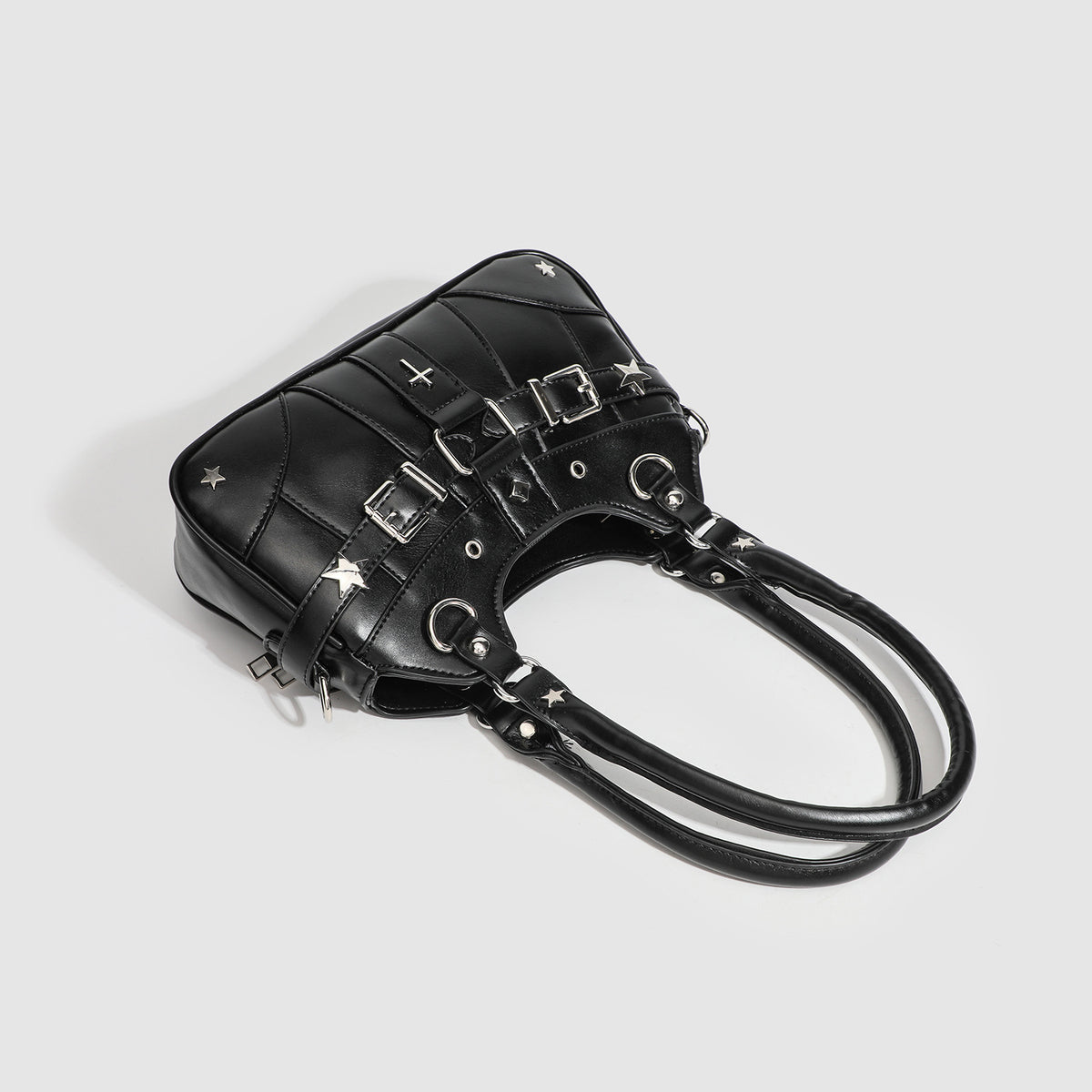 Small structured glossy leather-look crossbody bag with star-stud hardware, buckle strap detail, zip closure, and detachable