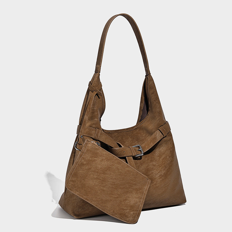 Slouchy oversized shoulder tote bag with matte textured finish, wrap-around buckle strap, and detachable front zip pouch