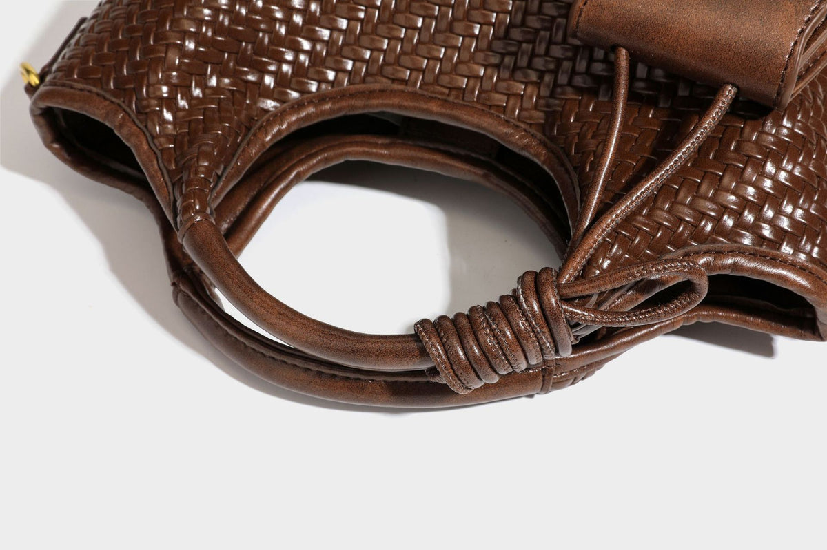Woven leather-look tote bag in mocha brown with knotted top handle, front flap pocket, and detachable crossbody strap with