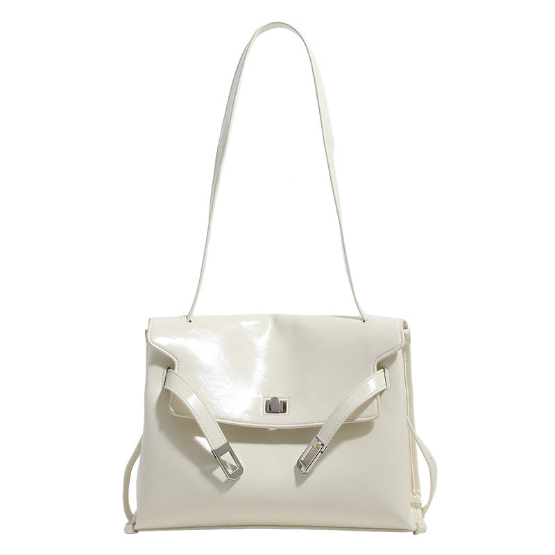 Structured rectangular flap shoulder bag in glossy leather-look finish with silver-tone turn-lock closure and adjustable