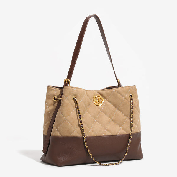 Two-tone tan quilted and dark brown leather-look tote bag with gold chain strap and floral knot emblem, detail view 2
