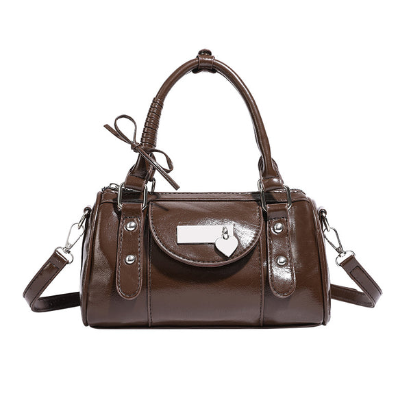 Kleine strukturierte Henkeltasche in glänzender Lederoptik mit Henkeln mit Schleifendetails und Vordertasche mit Herzverschluss, Detailansicht