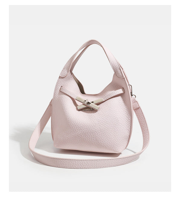 Compact pebbled leather-look shoulder bag with crossed silver-toned metal front closure, short top handle, and long, detail
