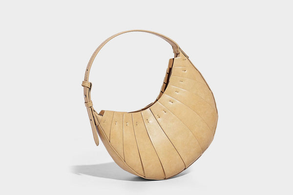 Crescent half-moon shoulder bag with vertical panel seaming, matte-satin leather-look finish, and adjustable gold-tone