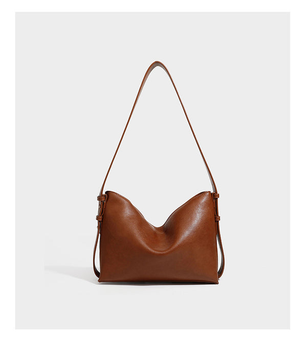 Slouchy suede-finish brown shoulder bag with long single strap and small gold-tone logo emblem on front, detail view 12