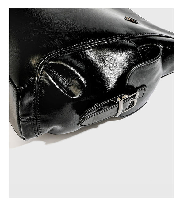Slouchy hobo shoulder bag with glossy leather-look finish, silver-tone chain drape across front, side buckle pockets, and