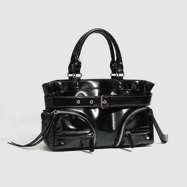 Black glossy structured tote bag with rivet and buckle detail, dual top handles, and detachable shoulder strap, detail view 4