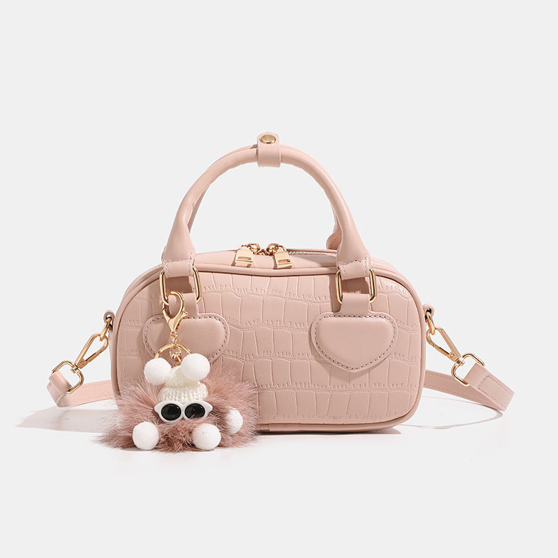 Mini croc-embossed barrel handbag with gold-tone hardware, dual zip top handles, detachable crossbody strap, and fluffy