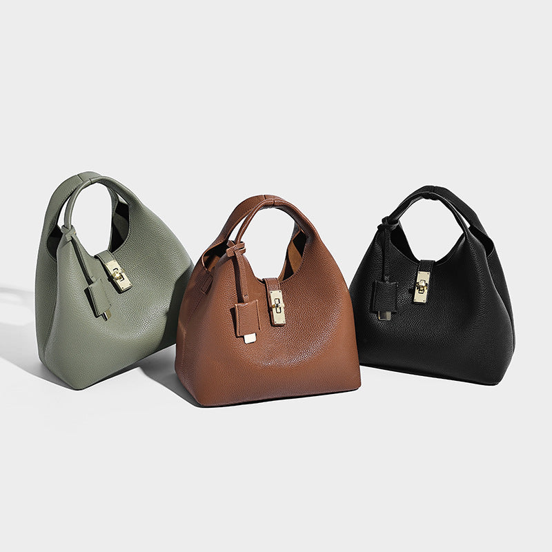 Structured pebbled-texture bucket bag with arched top handles, gold-tone turn-lock closure, and detachable shoulder strap