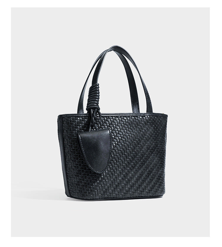 Strukturierte Tote Bag mit gewebter Oberfläche in Braun, goldfarbenen Metalldetails, seilumwickelten Tragegriffen, einer kleinen Fronttasche und weiteren Details