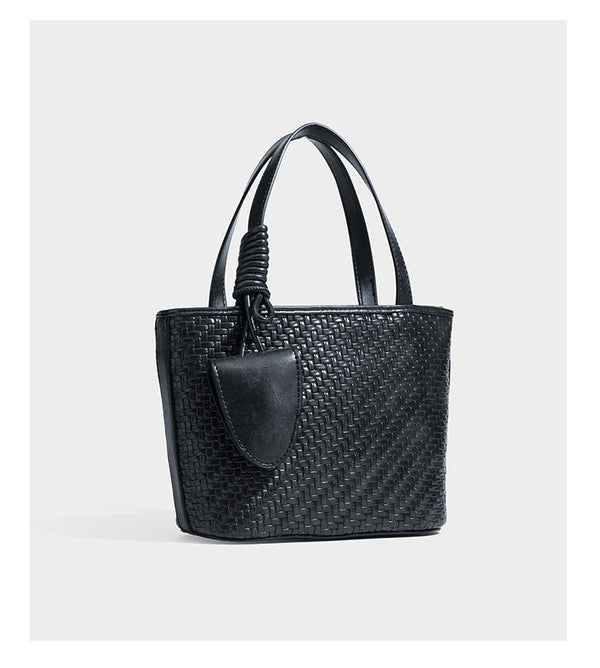 Strukturierte Tote Bag mit gewebter Oberfläche in Braun, goldfarbenen Metalldetails, seilumwickelten Tragegriffen, einer kleinen Fronttasche und weiteren Details