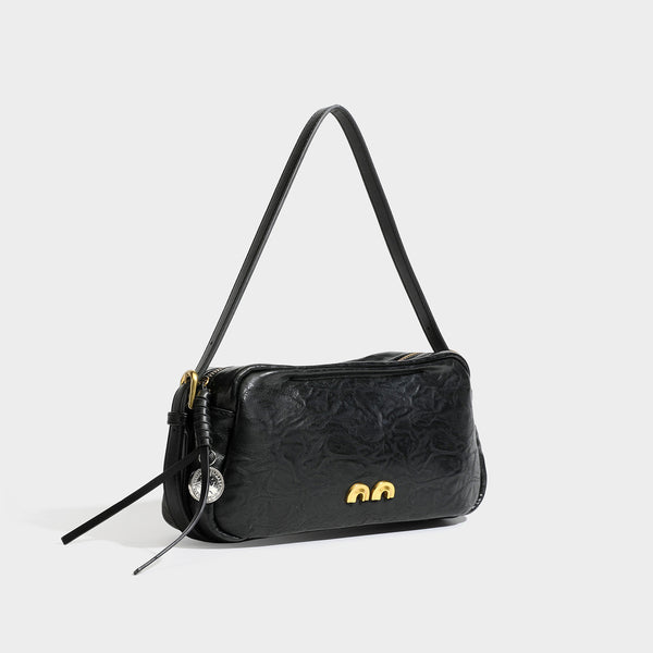 Compact black crinkled leather-look baguette shoulder bag with gold-tone arch hardware and adjustable strap, front view