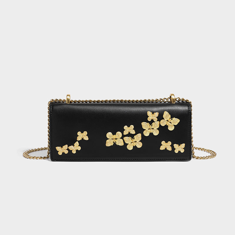 Slim rectangular crossbody bag with gold-tone butterfly metal appliqués and fine antiqued chain strap, detail view 6