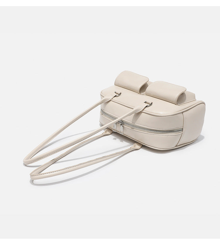 Structured glossy leather-look bowling shoulder bag with two front flap pockets, top zip closure, and long double shoulder