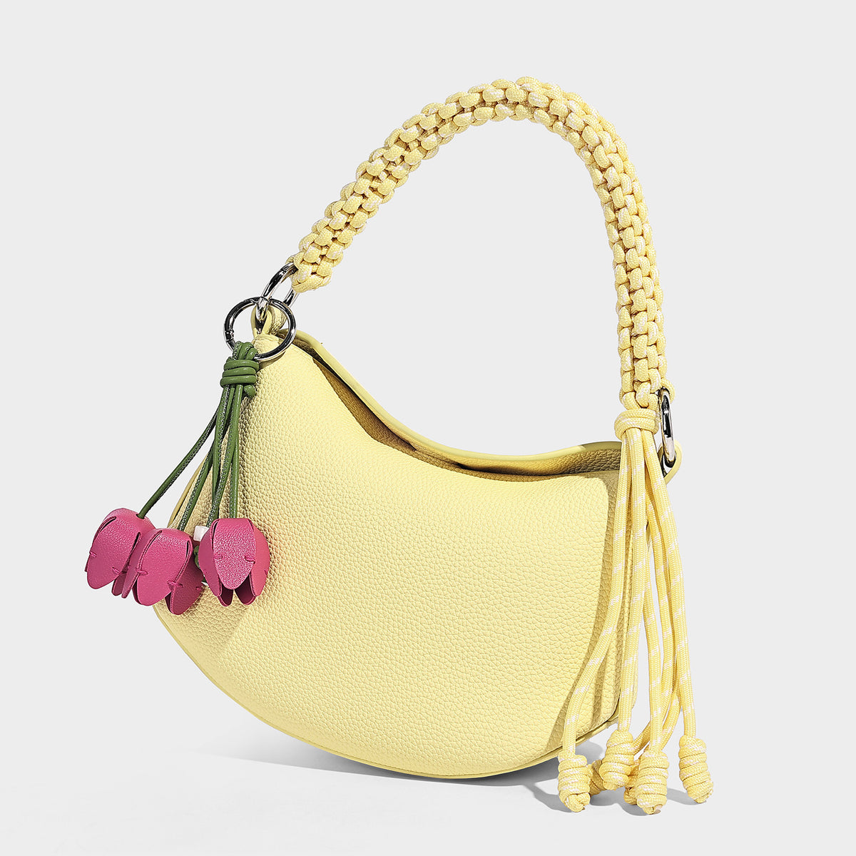 Small crescent half-moon bag in pebbled leather-look finish with braided top handle, silver-tone ring hardware, and, detail
