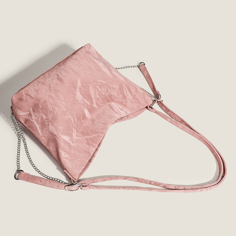 Blush pink slouchy hobo bag with crinkled sheen finish, silver-tone chain hardware, and adjustable shoulder strap, detail