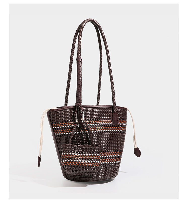 Light blue open-weave woven bucket tote bag with long braided shoulder straps, drawstring side ties, and attached mini pouch