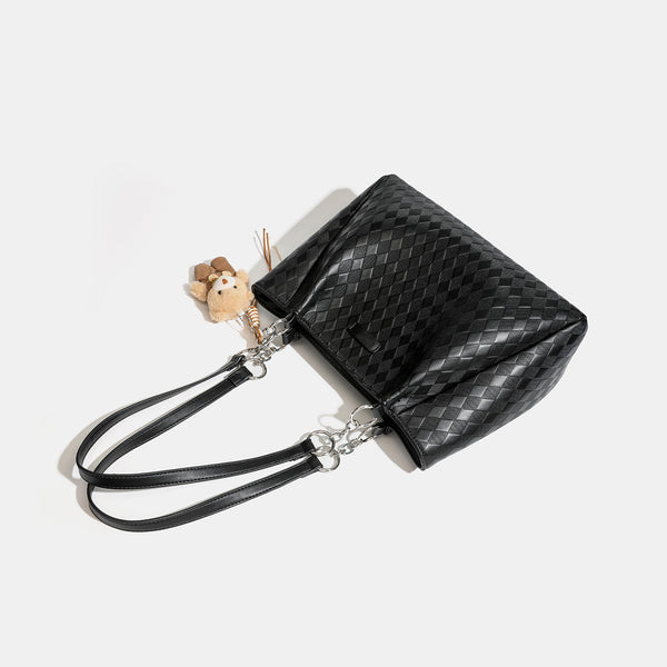 Black diamond-quilted leather-look tote bag with silver chain-ring shoulder straps and plush bear charm pendant, detail view