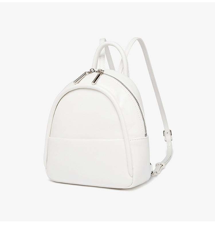 Kleine kuppelförmige Mini-Rucksackhandtasche in Pastellgelb mit glatter Lederoptik, oberem Bogenreißverschluss und silberfarbenen Details, Detailansicht
