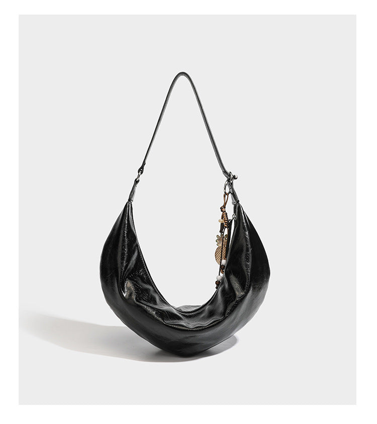 Lässig fallende Hobo-Schultertasche in Halbmondform mit glänzender, geknautschter Lederoptik, schmalem Riemen, silberfarbenen Ringbeschlägen und
