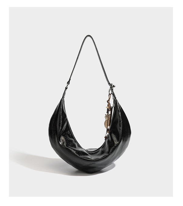 Lässig fallende Hobo-Schultertasche in Halbmondform mit glänzender, geknautschter Lederoptik, schmalem Riemen, silberfarbenen Ringbeschlägen und