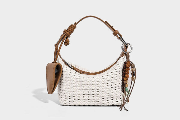 Woven crescent shoulder bag with leather-look knotted handle, zip top, attached mini pouch, and silver-tone hardware, detail
