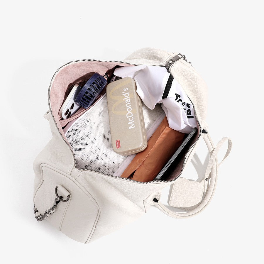 Large cream white pebbled leather-look barrel travel bag with twin top handles, chunky chain shoulder strap, front zip