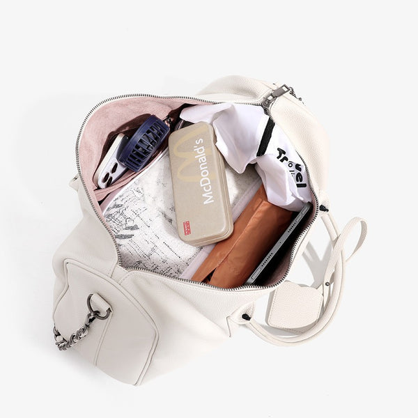 Large cream white pebbled leather-look barrel travel bag with twin top handles, chunky chain shoulder strap, front zip
