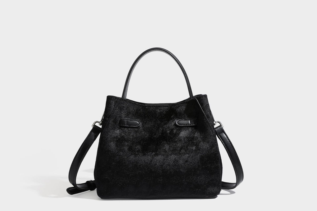 Small structured bucket satchel in embossed velvet-texture fabric with silver turn-lock hardware, rounded top handle, and