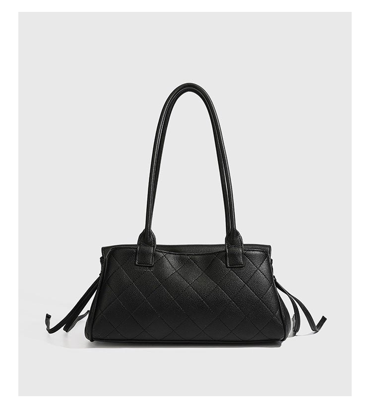 Structured black diamond-quilted shoulder bag with gold-tone turn-lock flap closure and dual round shoulder straps, detail