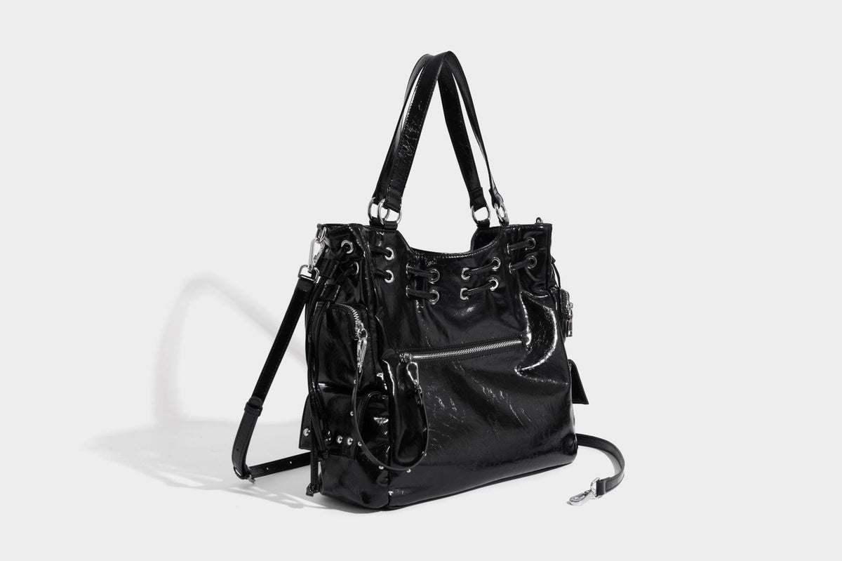 Glossy crinkled leather-look tote bag with silver grommet lace-up front detail, dual top handles, and detachable shoulder