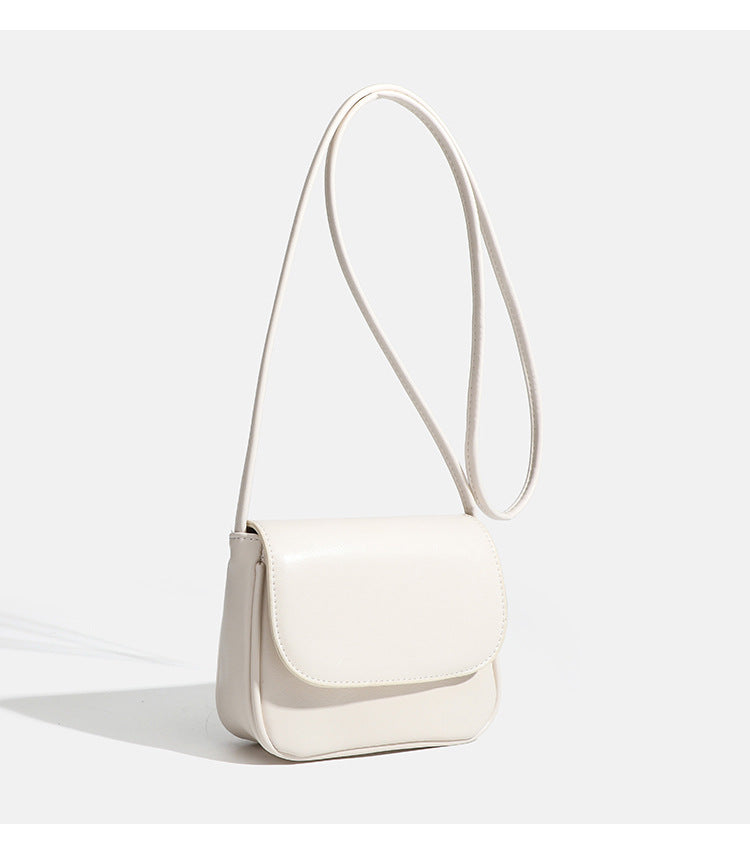 Compact rounded rectangular flap crossbody bag with glossy leather-look finish and long shoulder strap, detail view 17