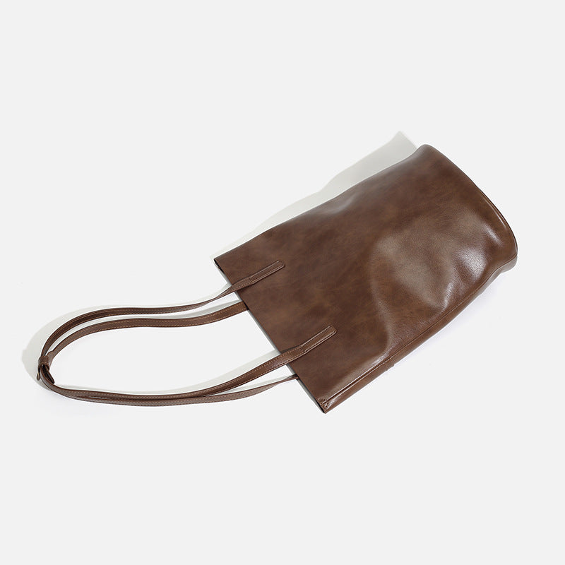 Large black smooth leather-look bucket tote bag with long shoulder straps and open top, detail view 3