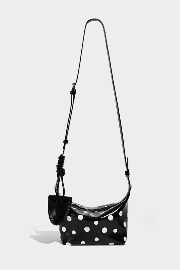 Kompakte glänzende Hobo-Schultertasche in Schwarz mit weißen Punkten, Reißverschluss, Beschlägen in Gunmetal und befestigtem Überschlag vorne