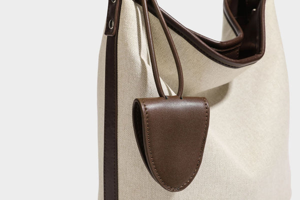 Oatfarbene Canvas-Schultertasche mit dunkelbraunem Besatz in Lederoptik, langem verstellbarem Riemen und angebrachter Mini-Tasche mit Überschlag, Detailansicht