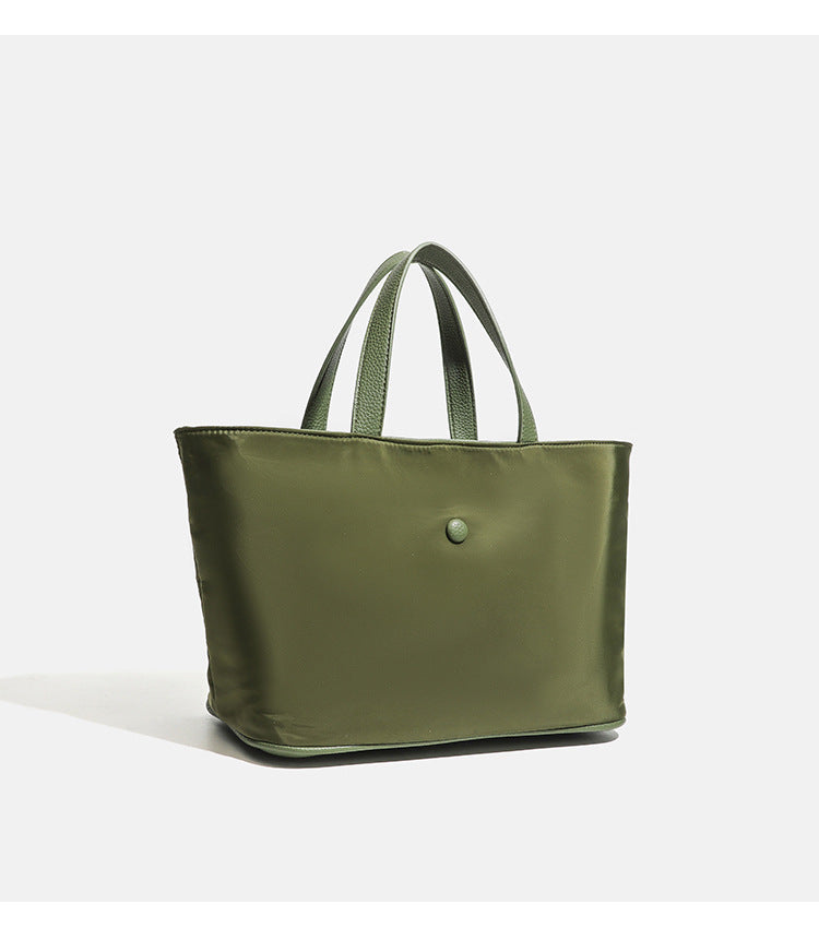 Structured lightweight nylon tote bag with textured double top handles and snap-button front detail, detail view 15